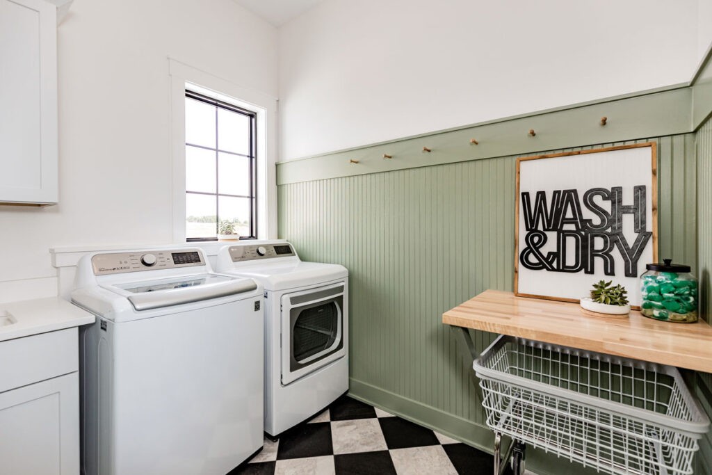 A laundry room showing two walls with an accented wall painting a light gray-green.