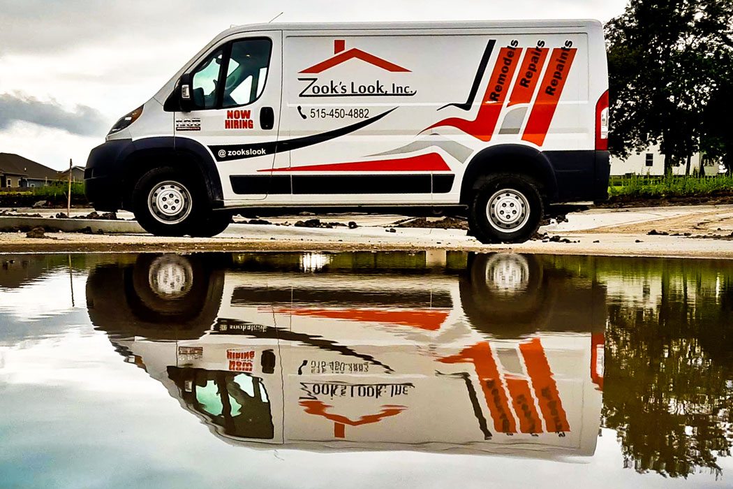 Zook's Look van next to a body of water. The van is shown reflected in the water.